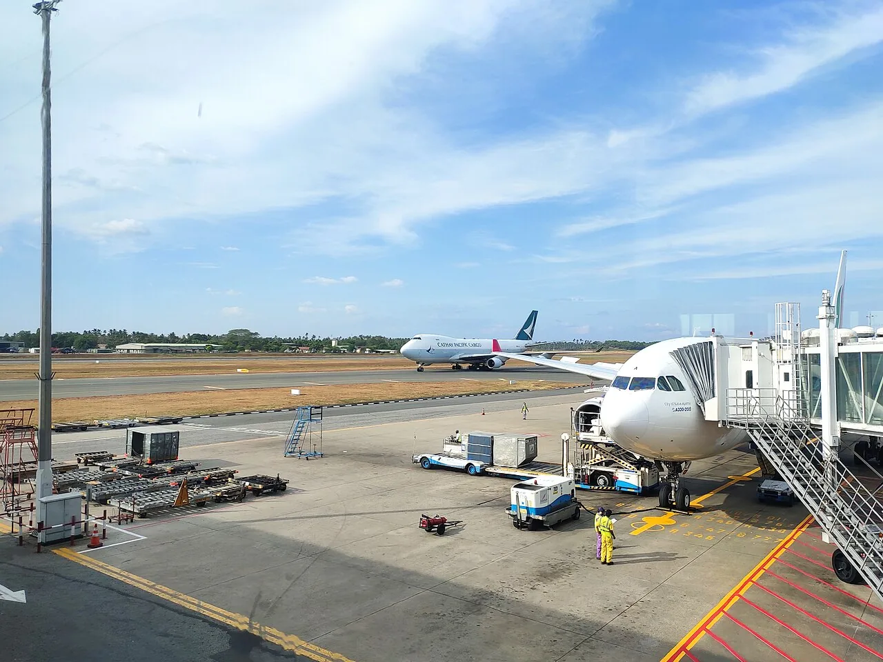 View of the runway from inside of Bandaranaike International Airport, Colombo, Sri Lanka. A Cathay Pacific Airways cargo plane is landing.