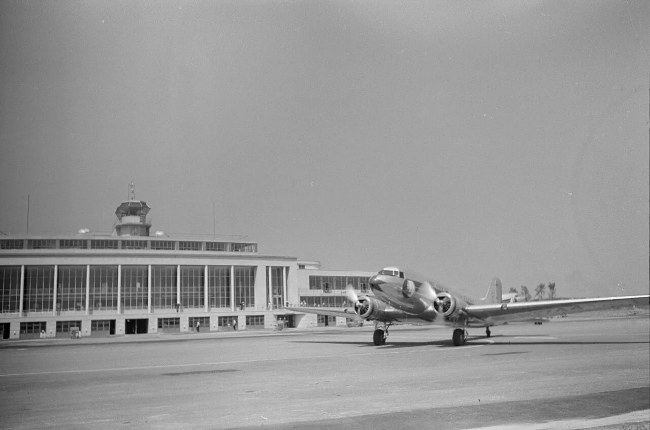 A Douglas DC-3 of Eastern Air Lines taxiing away from the terminal at Washington National Airport . Original title: "A plane taxiing off at the municipal airport in Washington, D.C."