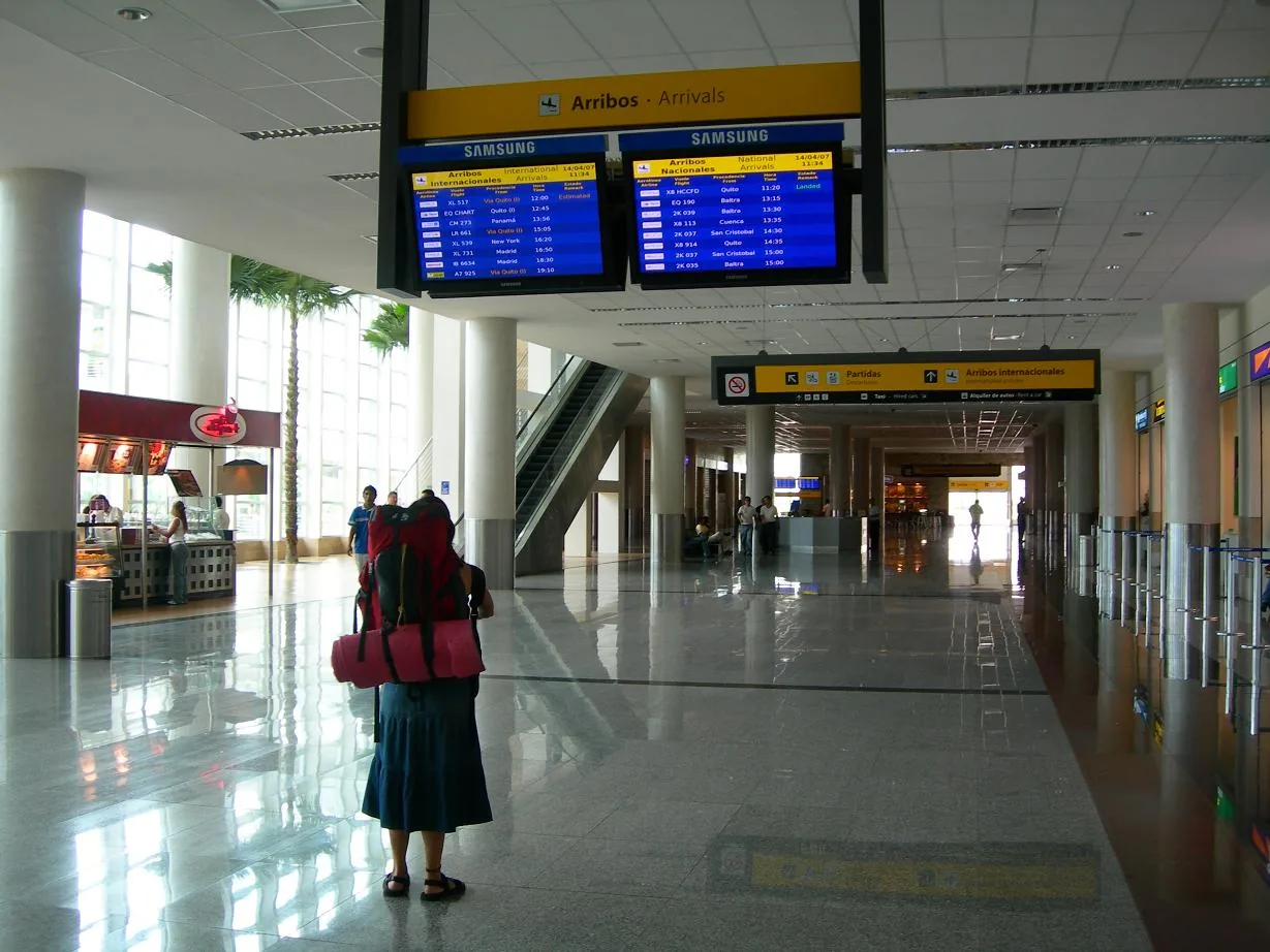 Turista consultando horarios en la zona de llegadas del Aeropuerto internacional de Guayaquil