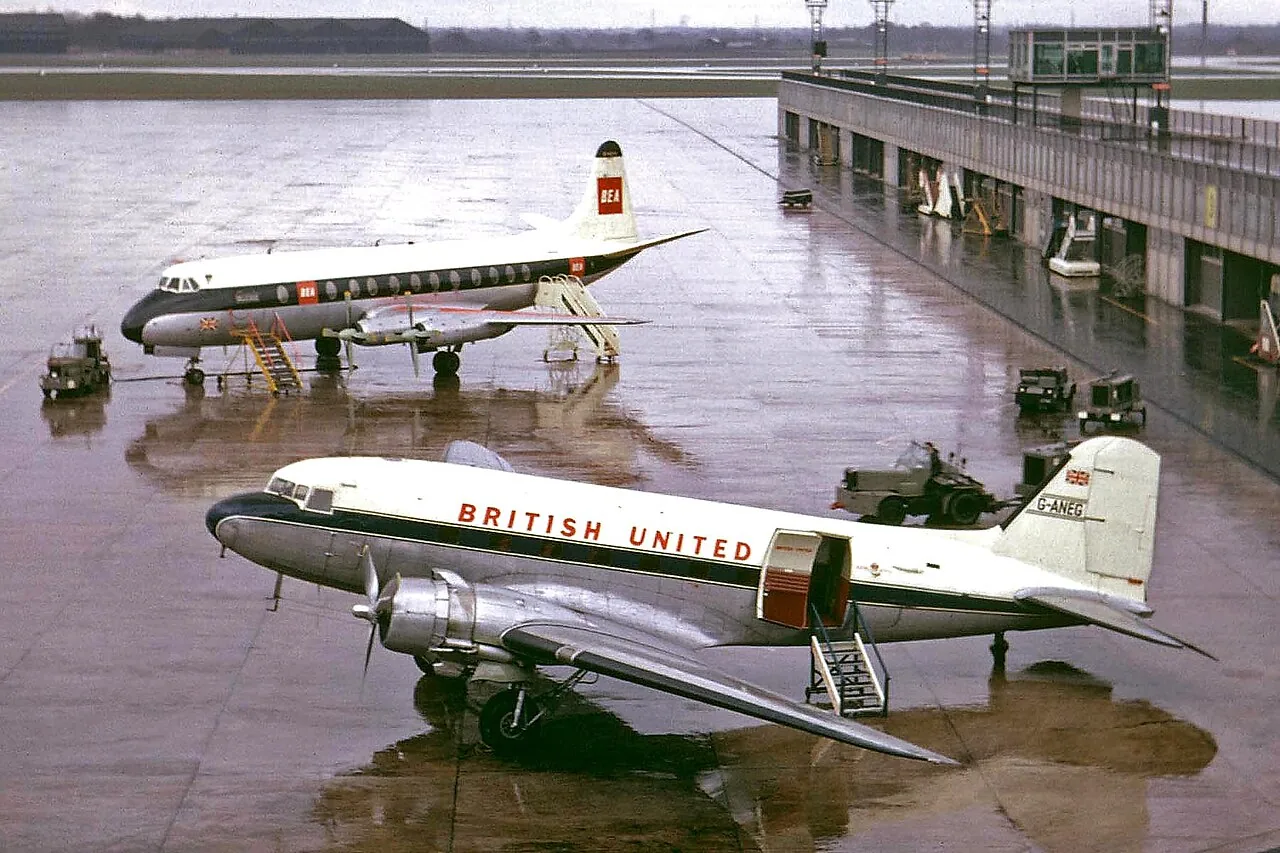 "G-ANEG Douglas C-47 British United Airways MAN 14APR63 A busy and wet day in Manchester... 1963 style... Stand 1, Pier B. Quite a lack of ground handling equipment at Manchester back in 1963, especially when compared to