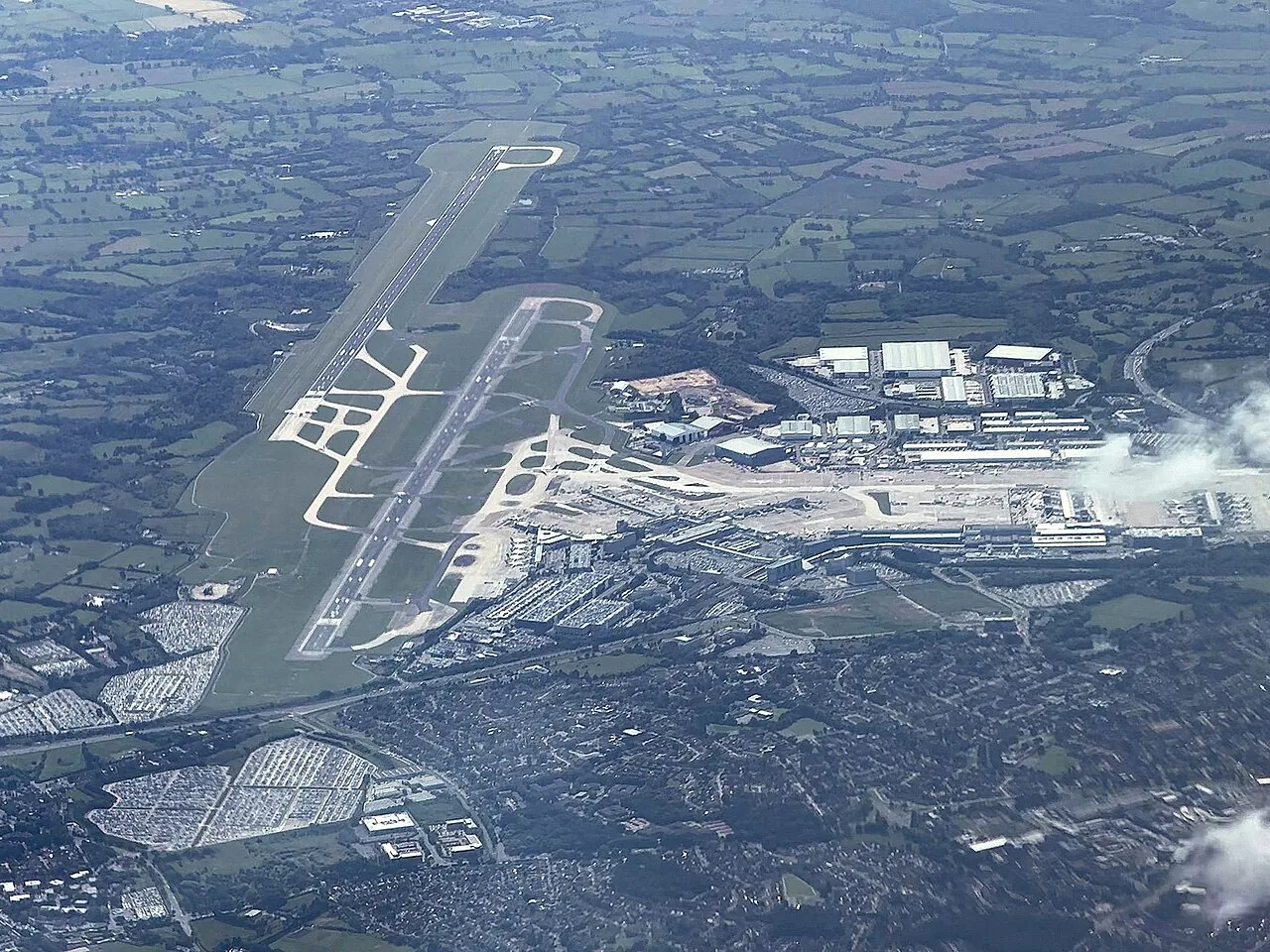 An air to ground photo of Manchester Airport, looking southwest towards runways 23L/R