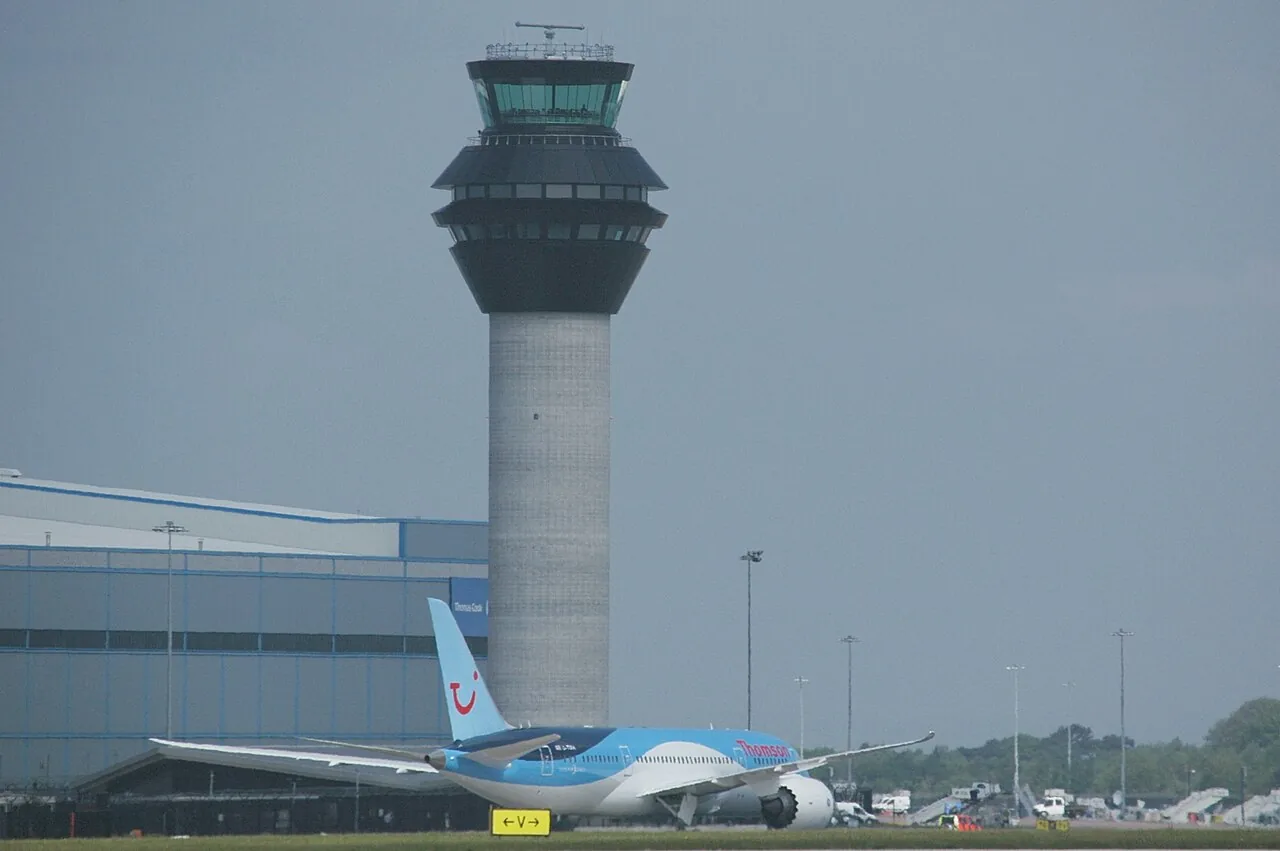 Manchester Airport's new control tower, opened in June 2013, with Thomson Airways' first Boeing 787 Dreamliner G-TUIA taxying in at the end of its delivery flight.
